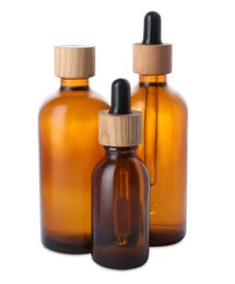 Different bottles of essential oil on white background