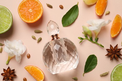 Photo of Flat lay composition with bottleperfume, citrus fruits and flowers on pink background