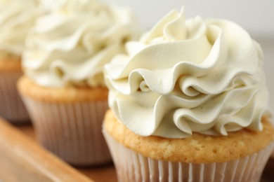 Photo of Tasty cupcakes with vanilla cream on table, closeup