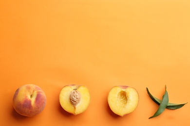 Flat lay composition with fresh peaches on orange background. Space for text