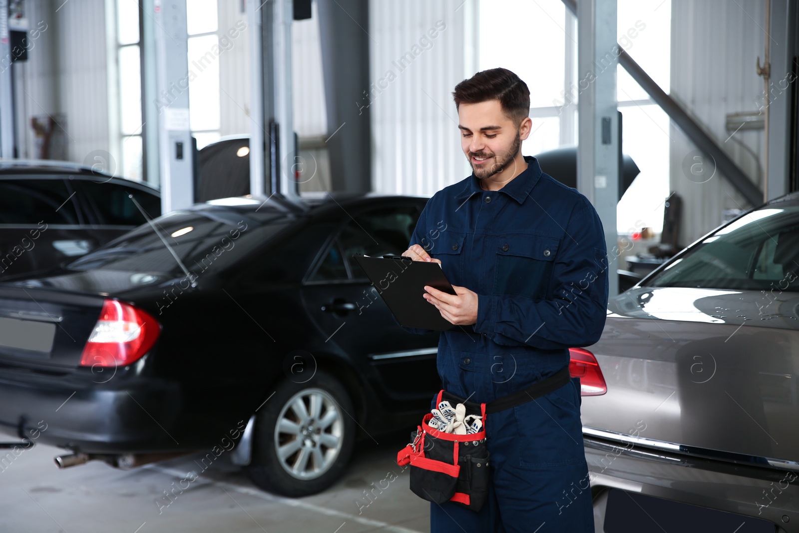 Photo of Portrait of technician with clipboard at automobile repair shop