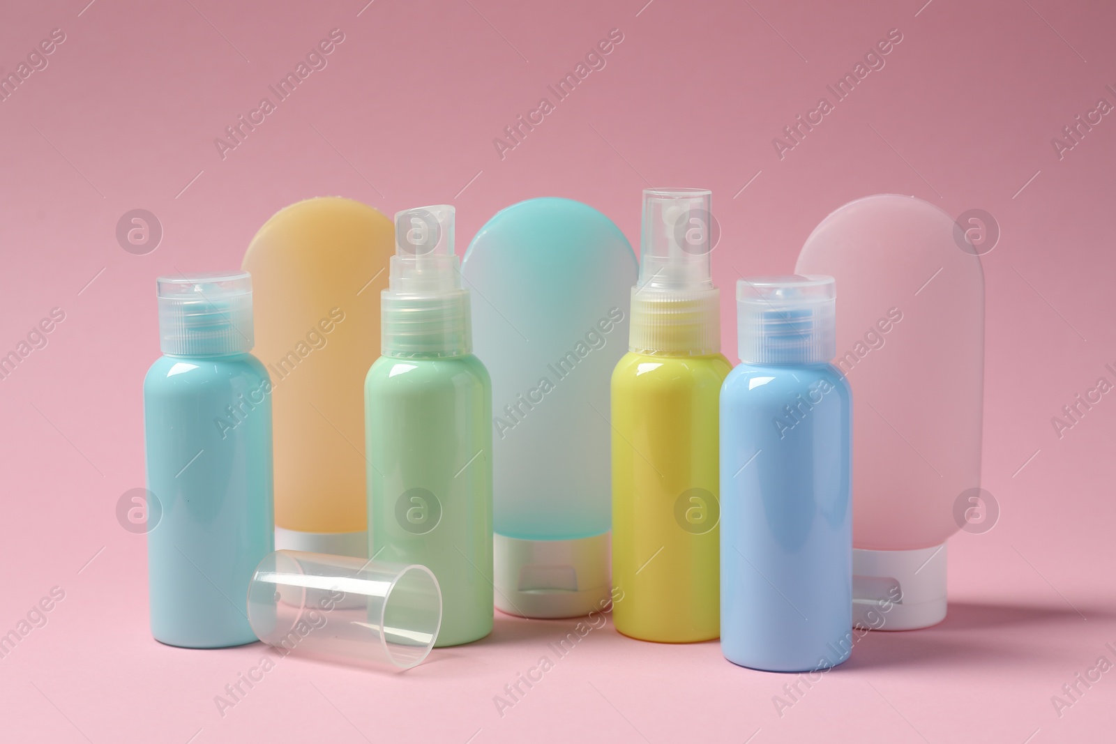 Photo of Cosmetic travel kit on pink background. Bath accessories