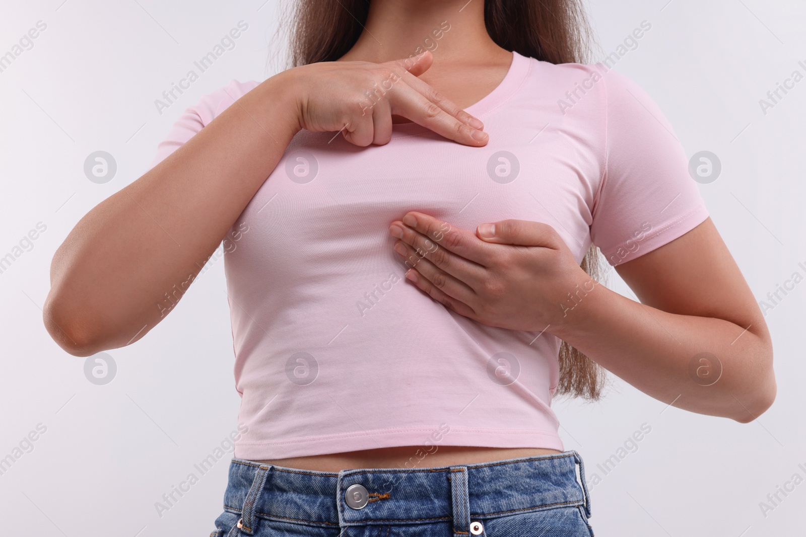 Photo of Woman doing breast self-examination on white background, closeup