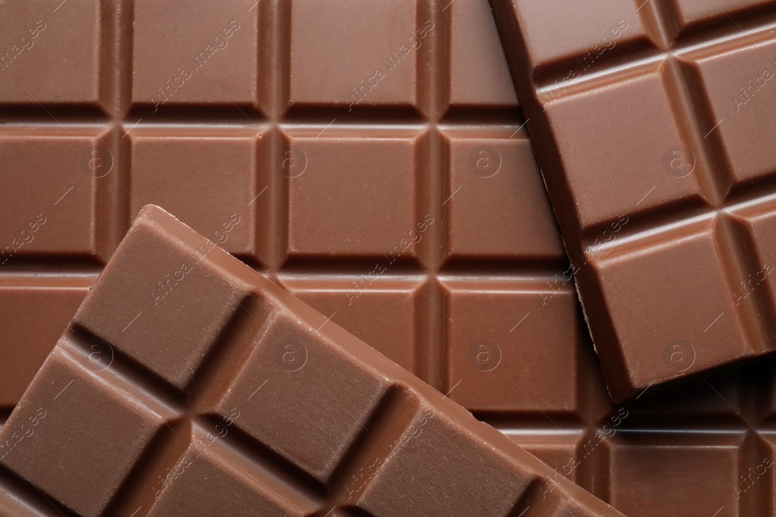 Photo of Delicious milk chocolate bars as background, top view