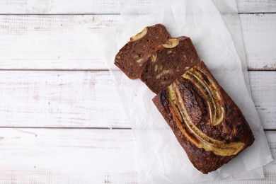 Photo of Delicious banana bread on white wooden table, top view. Space for text