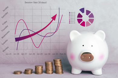Image of White piggy bank with coins and graphs on light background
