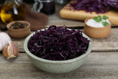 Photo of Tasty red cabbage sauerkraut with parsley on wooden table