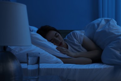 Photo of Beautiful young woman sleeping in bed at night