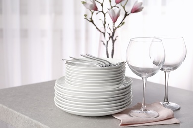 Set of clean dishes on table against blurred background