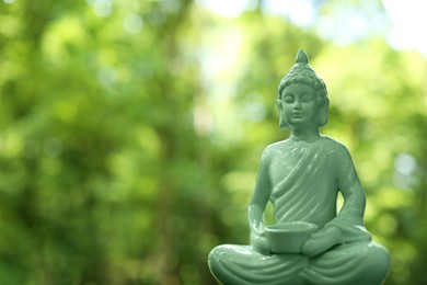 Photo of Decorative Buddha statue on blurred background. Space for text