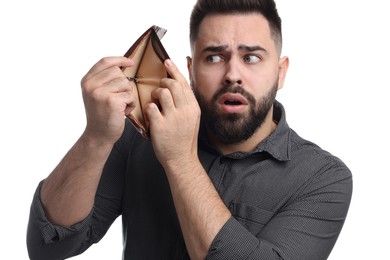 Confused man showing empty wallet on white background