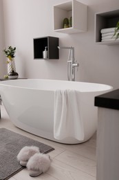 Stylish bathroom interior with modern white tub