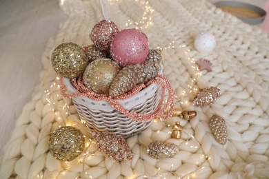 Beautiful Christmas tree baubles and fairy lights on white knitted fabric