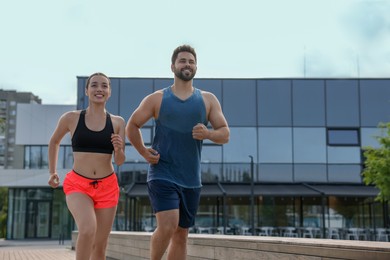 Photo of Healthy lifestyle. Happy couple running outdoors, space for text