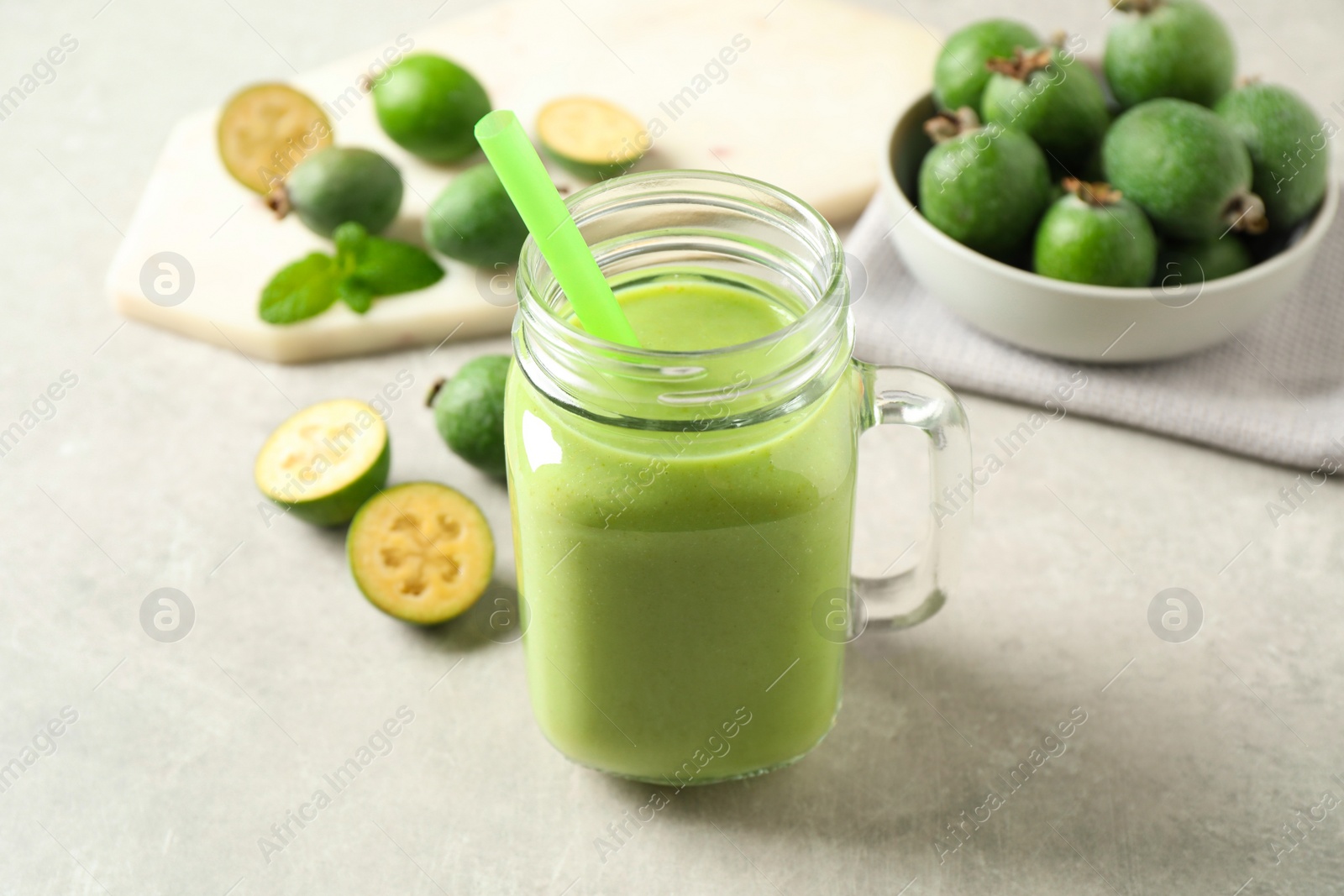 Photo of Fresh feijoa smoothie in mason jar on light table, closeup