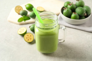 Photo of Fresh feijoa smoothie in mason jar on light table, closeup