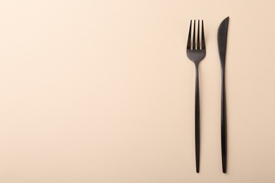 Photo of Stylish cutlery on beige table, top view. Space for text