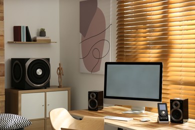 Photo of Modern computer with audio speaker system in bright room