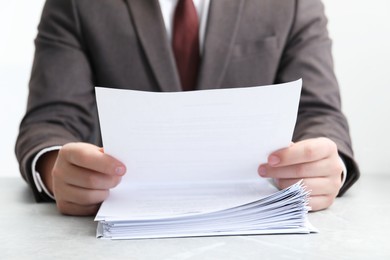 Man reading document at table in office, closeup