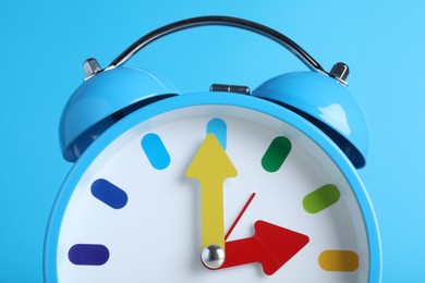 Photo of Alarm clock on light blue background, closeup