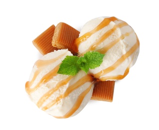 Scoops of delicious ice cream with mint, caramel sauce and candies on white background, top view