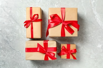 Christmas gift boxes with red bows on light grey marble background, flat lay