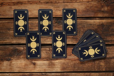 Photo of Tarot cards on wooden table, flat lay. Reverse side