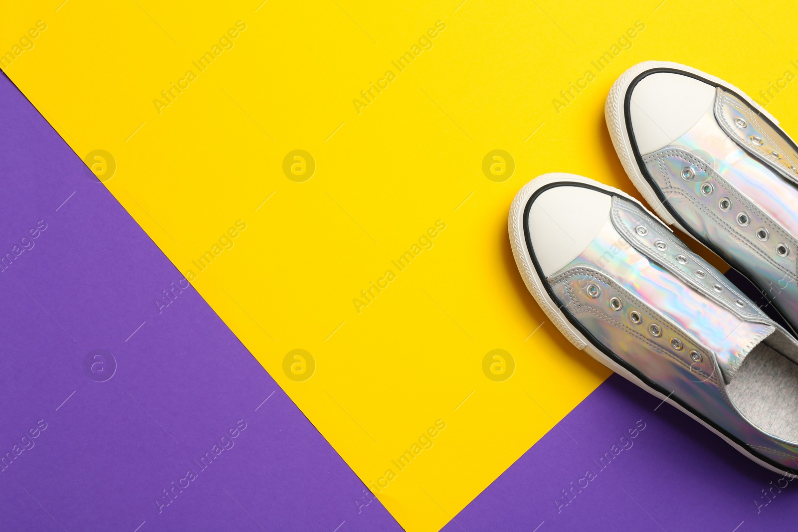 Photo of Pair of stylish sneakers on color background, top view with space for text