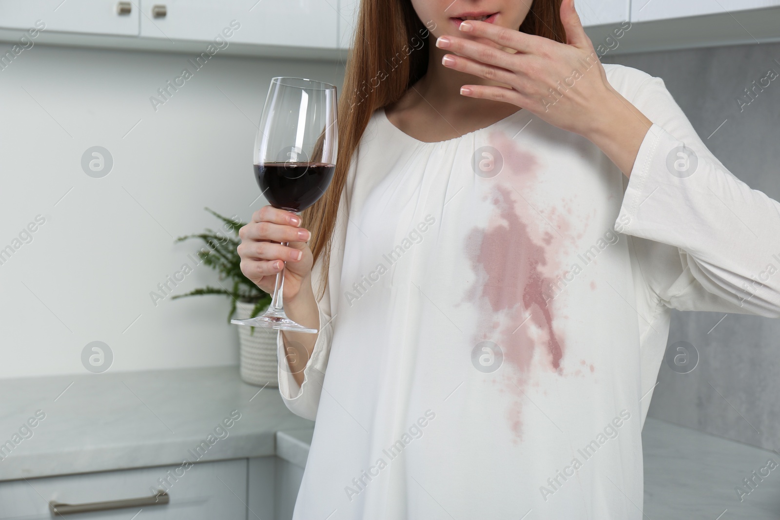 Photo of Embarrassed woman with stain on her clothes and glass of wine indoors, closeup