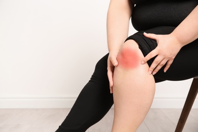 Photo of Overweight woman on light background, closeup of legs