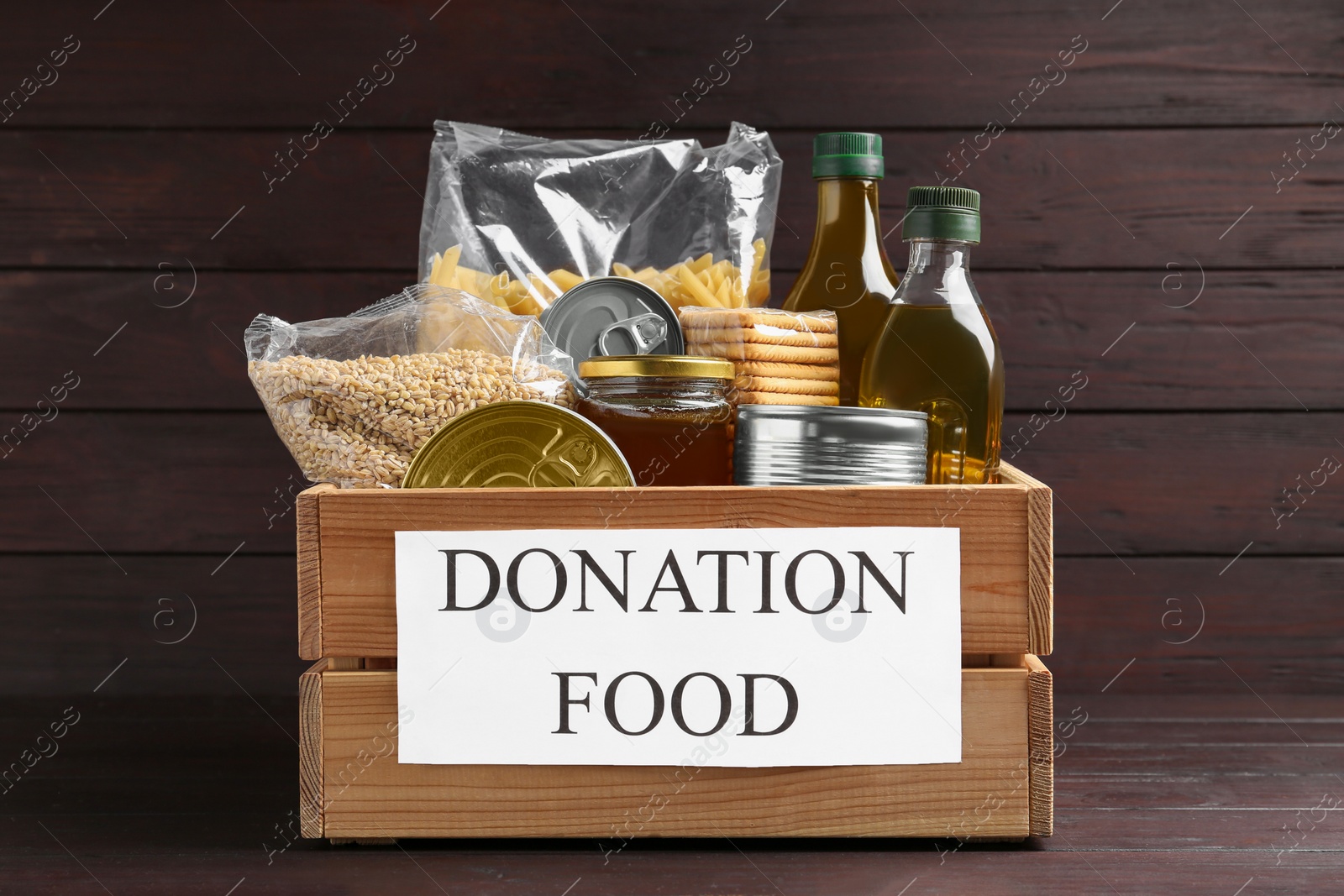 Photo of Donation crate with food on wooden table