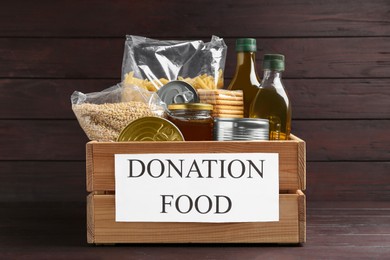 Donation crate with food on wooden table