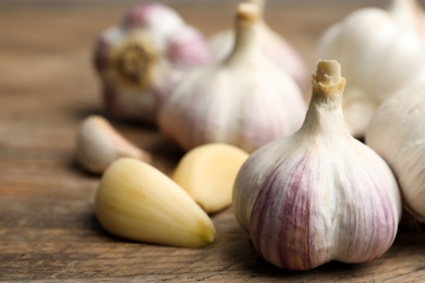 Photo of Fresh organic garlic on wooden table, closeup