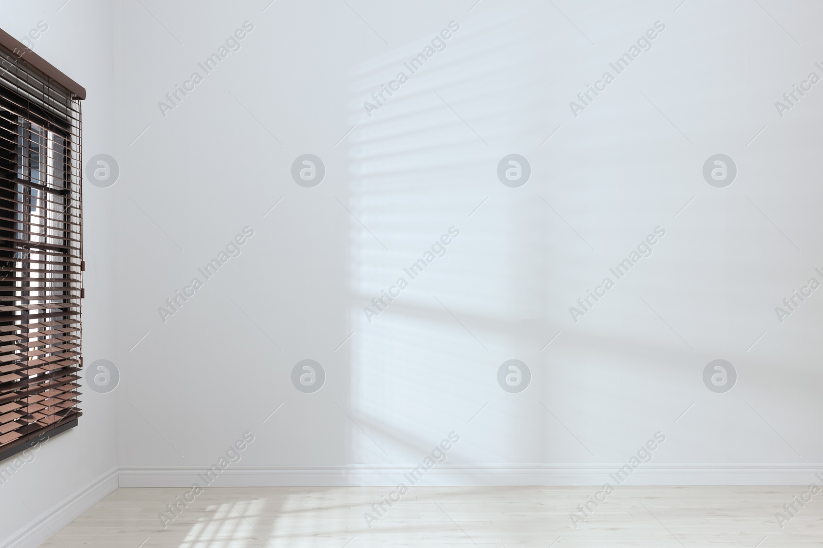 Photo of Empty room with white walls, large window and wooden floor