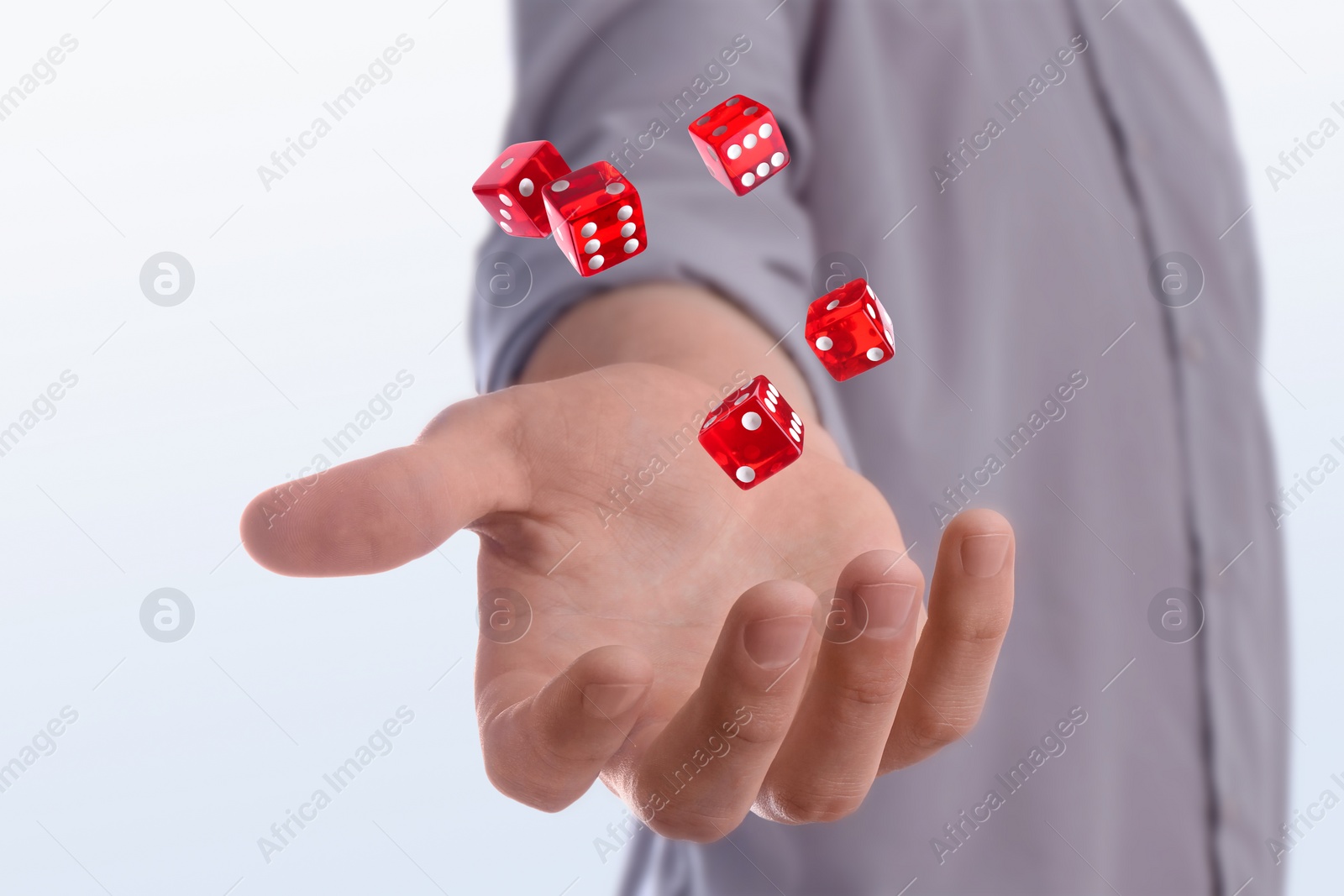 Image of Man throwing red dice on white background, closeup