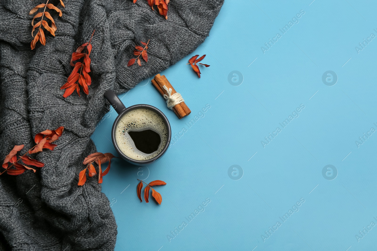 Photo of Flat lay composition with hot drink and warm plaid on light blue background, space for text