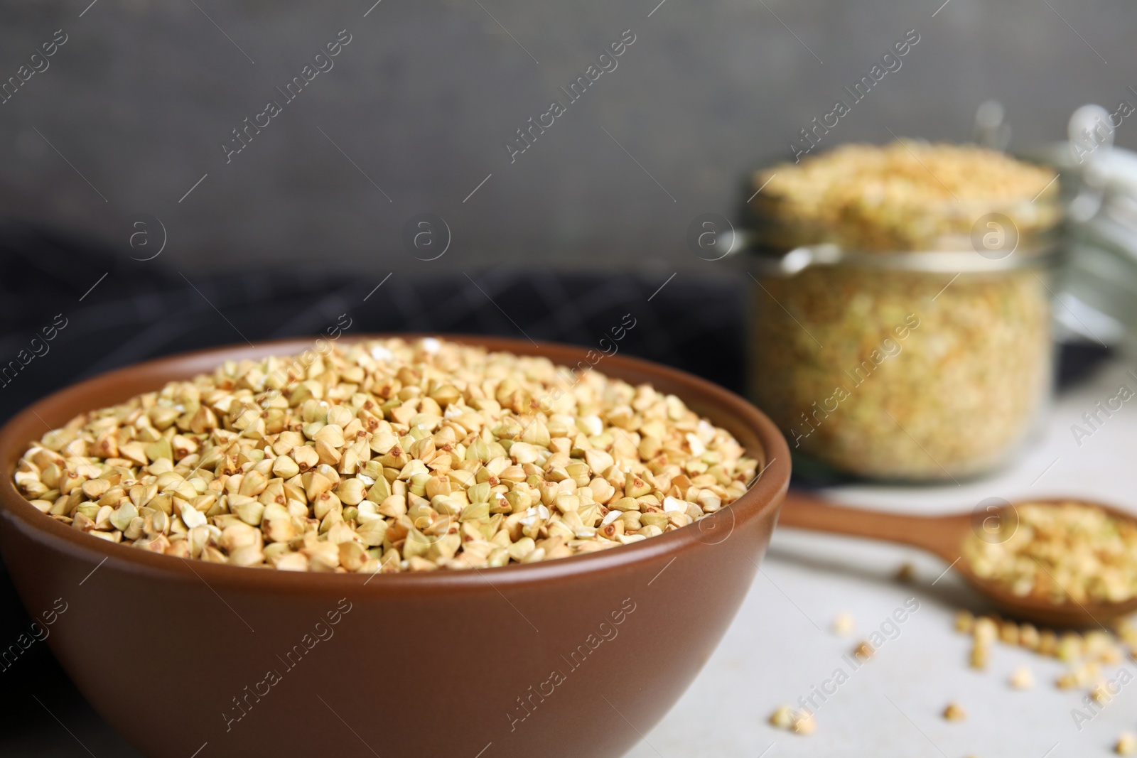 Photo of Uncooked green buckwheat grains in bowl on table