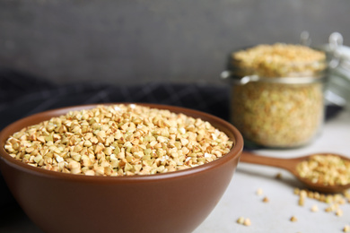 Uncooked green buckwheat grains in bowl on table