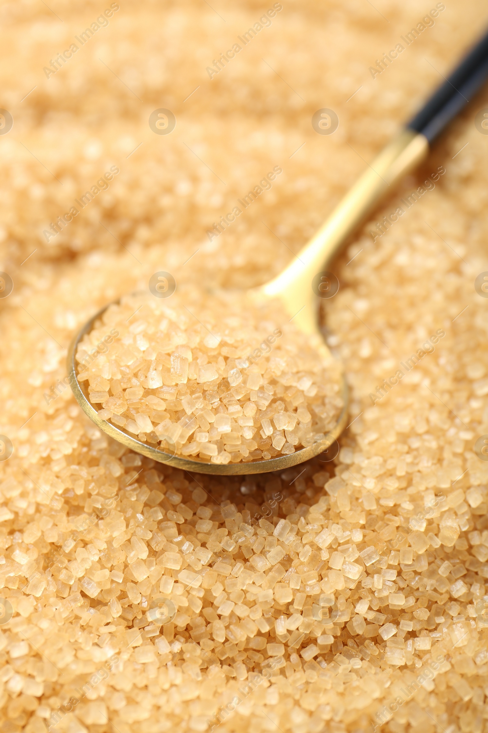 Photo of Spoon on granulated brown sugar, closeup view