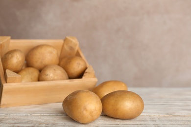 Photo of Fresh ripe organic potatoes on wooden table