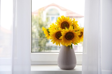 Bouquet of beautiful sunflowers on window sill indoors