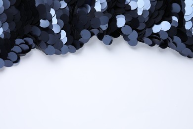 Beautiful shiny sequin fabric on white background, top view. Space for text