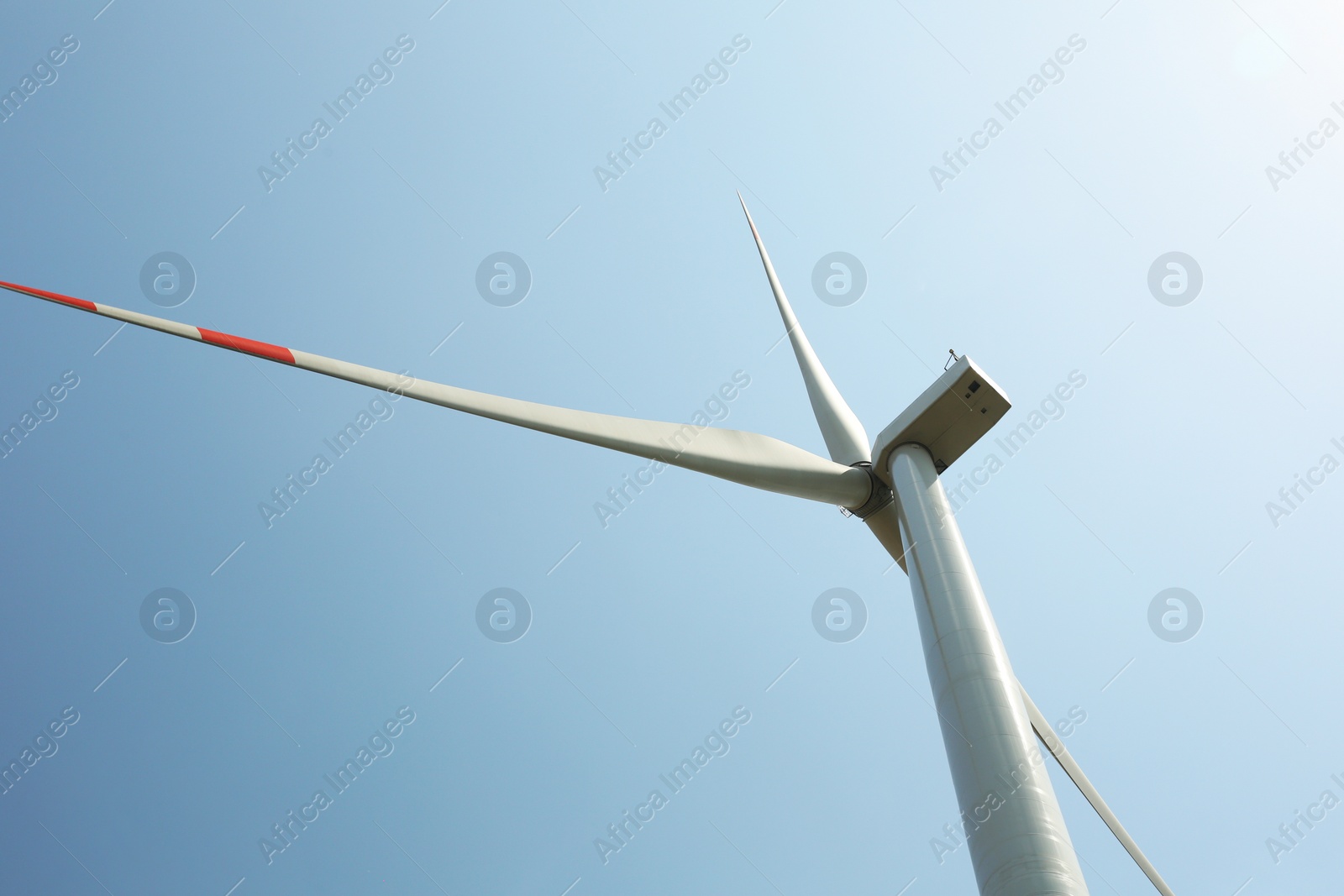 Photo of Modern wind turbine against blue sky, low angle view. Energy efficiency