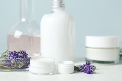 Herbal cosmetic products, laboratory glassware and ingredients on white table