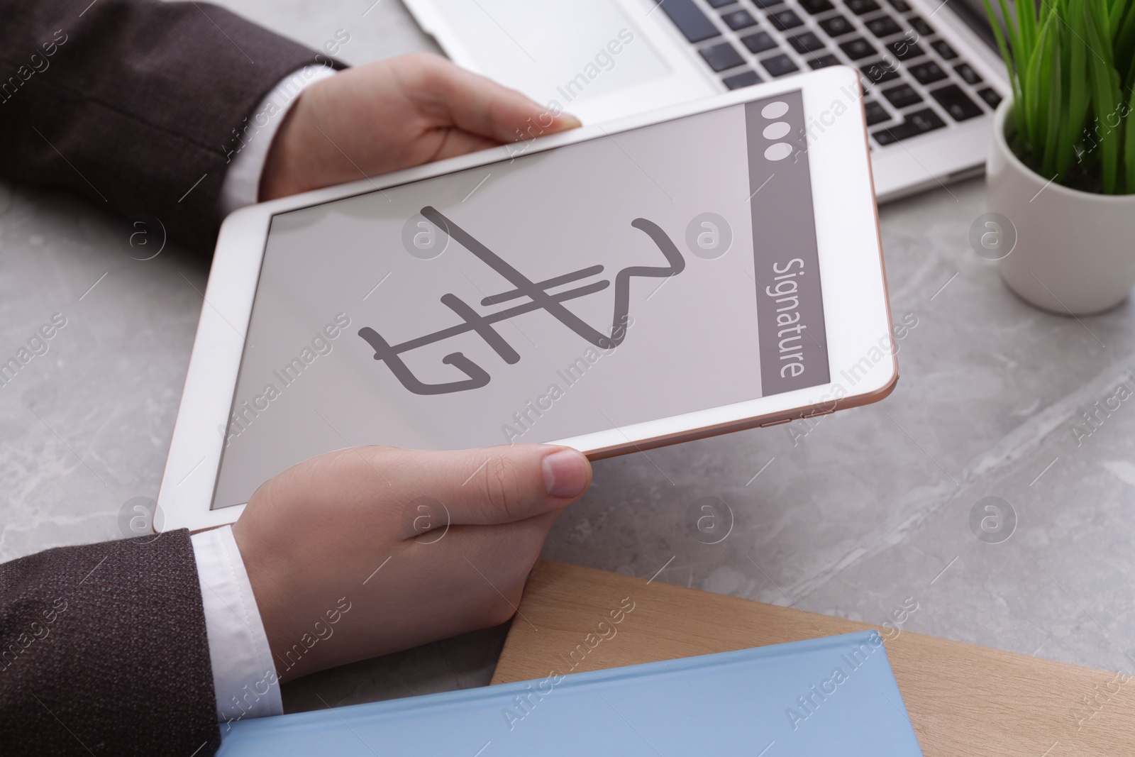 Image of Electronic signature. Man using tablet at table, closeup