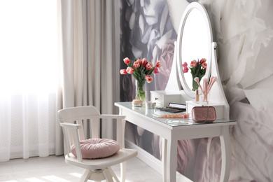 Stylish room interior with elegant dressing table and floral wallpaper