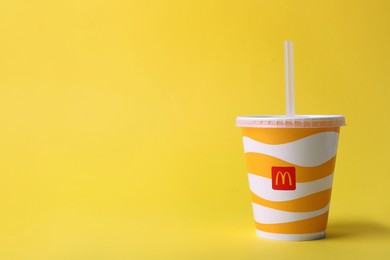 MYKOLAIV, UKRAINE - AUGUST 12, 2021: Cold McDonald's drink on yellow background. Space for text