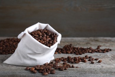 Photo of Bag of roasted coffee beans on wooden table. Space for text