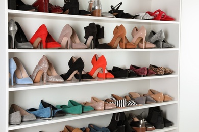 Photo of Shelving unit with different shoes. Element of dressing room interior