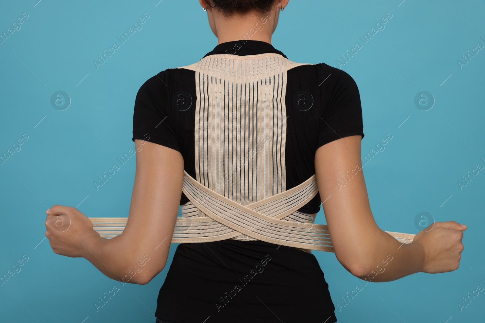 Photo of Closeup of woman with orthopedic corset on blue background, back view